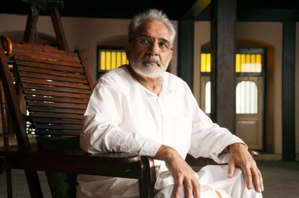 Kulbhushan Kharbanda sitting on a chair wearing white colored kurta pyjama.