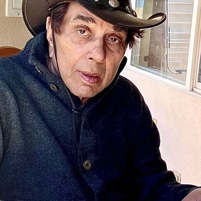 Dharmendra wearing brown hat.