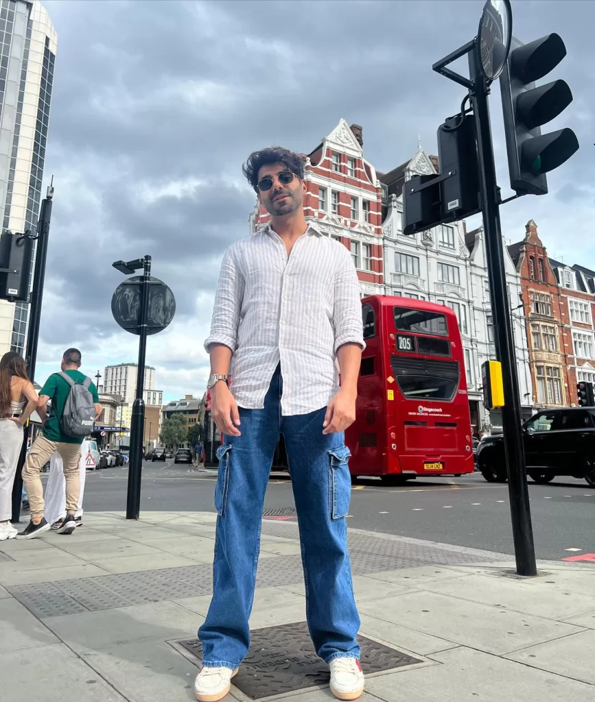 Aparshakti khurana wearing white shirt and blue jeans.