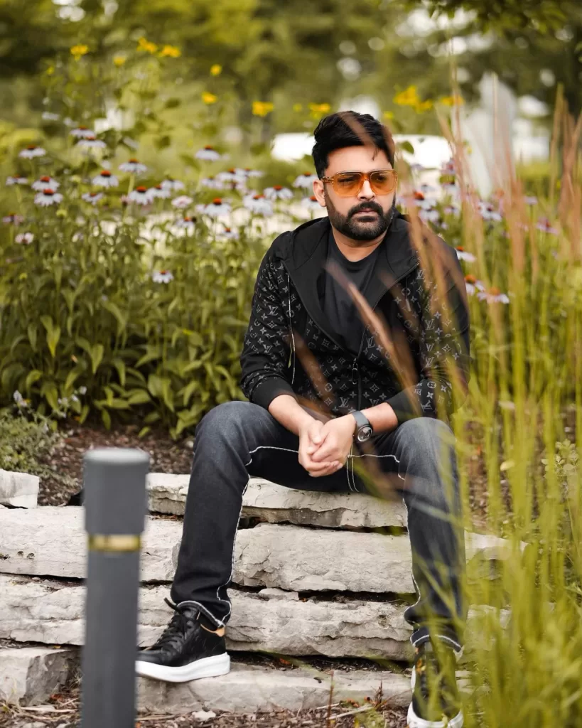 Kapil Sharma sitting in a garden.